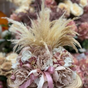 Centrotavola con fiori artificiali, base in legno composto da peonie rosa ortensie e rami di pampas