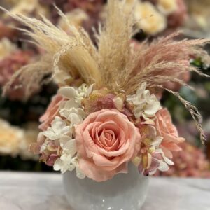 Centrotavola con fiori artificiali composto da rose in velluto di colore rosa, ortensie e rami di pampas Ø 25 cm