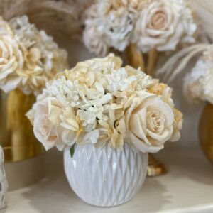 Centrotavola con fiori artificiali composto da rose in velluto panna e ortensie