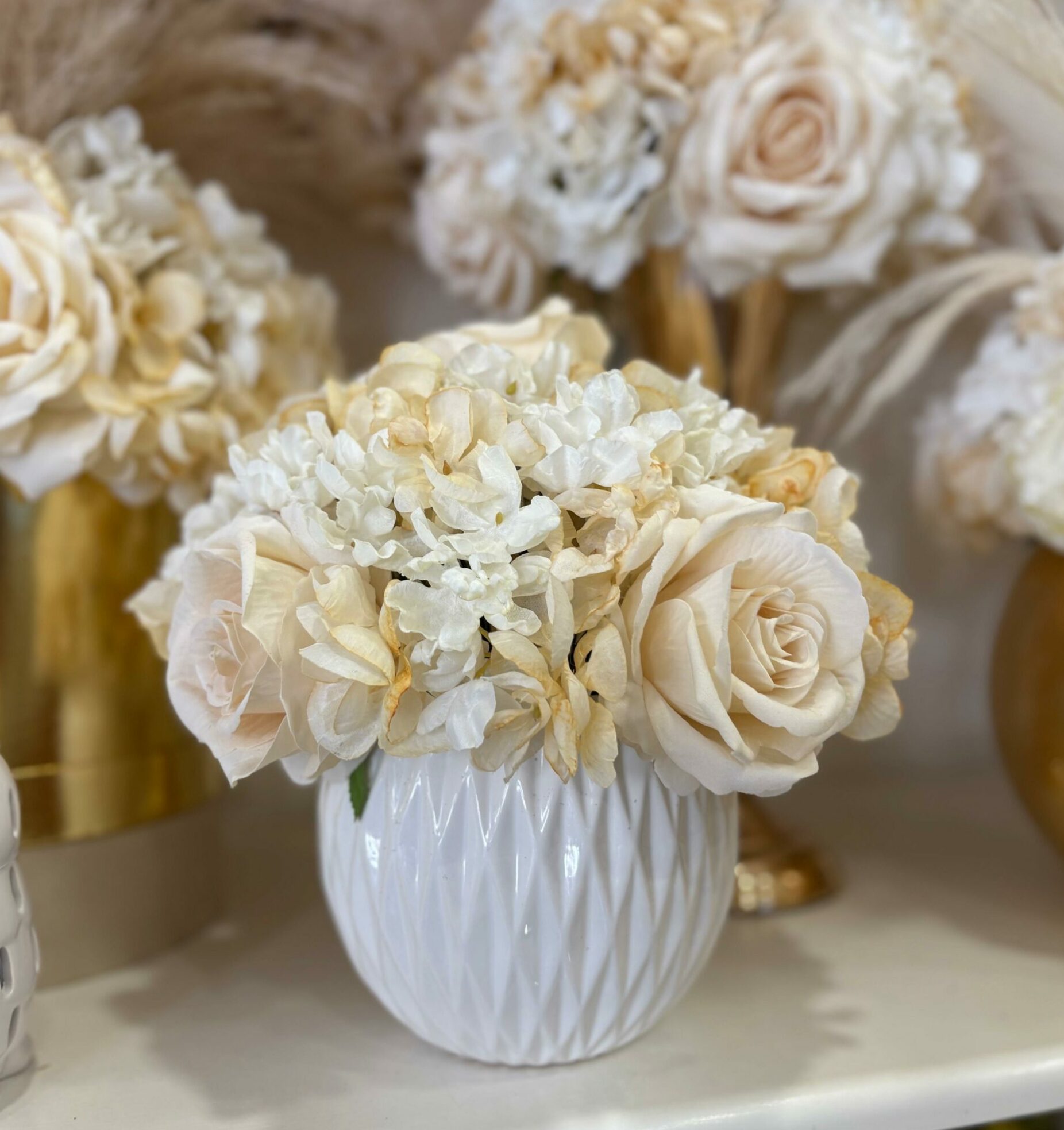 Centrotavola con fiori artificiali composto da rose in velluto panna e ortensie