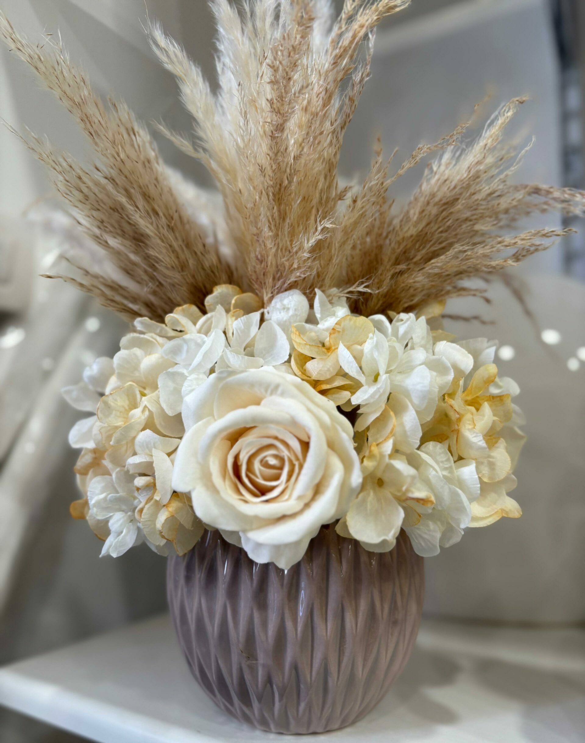 Centrotavola con fiori artificiali composto da rose in velluto panna, ortensie e pampas  Ø 25 cm