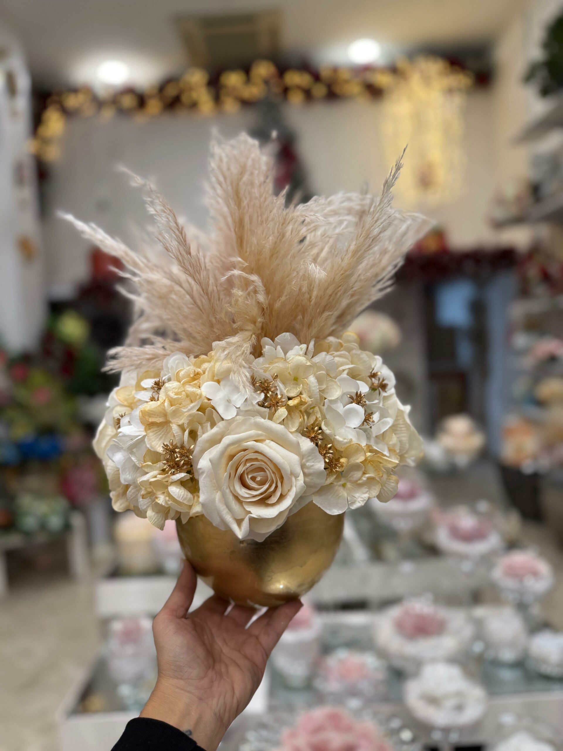 Centrotavola, Ampolla oro in vetro con fiori artificiali composto da boccioli di rose panna in velluto, ortensie e pampas Ø 25 cm