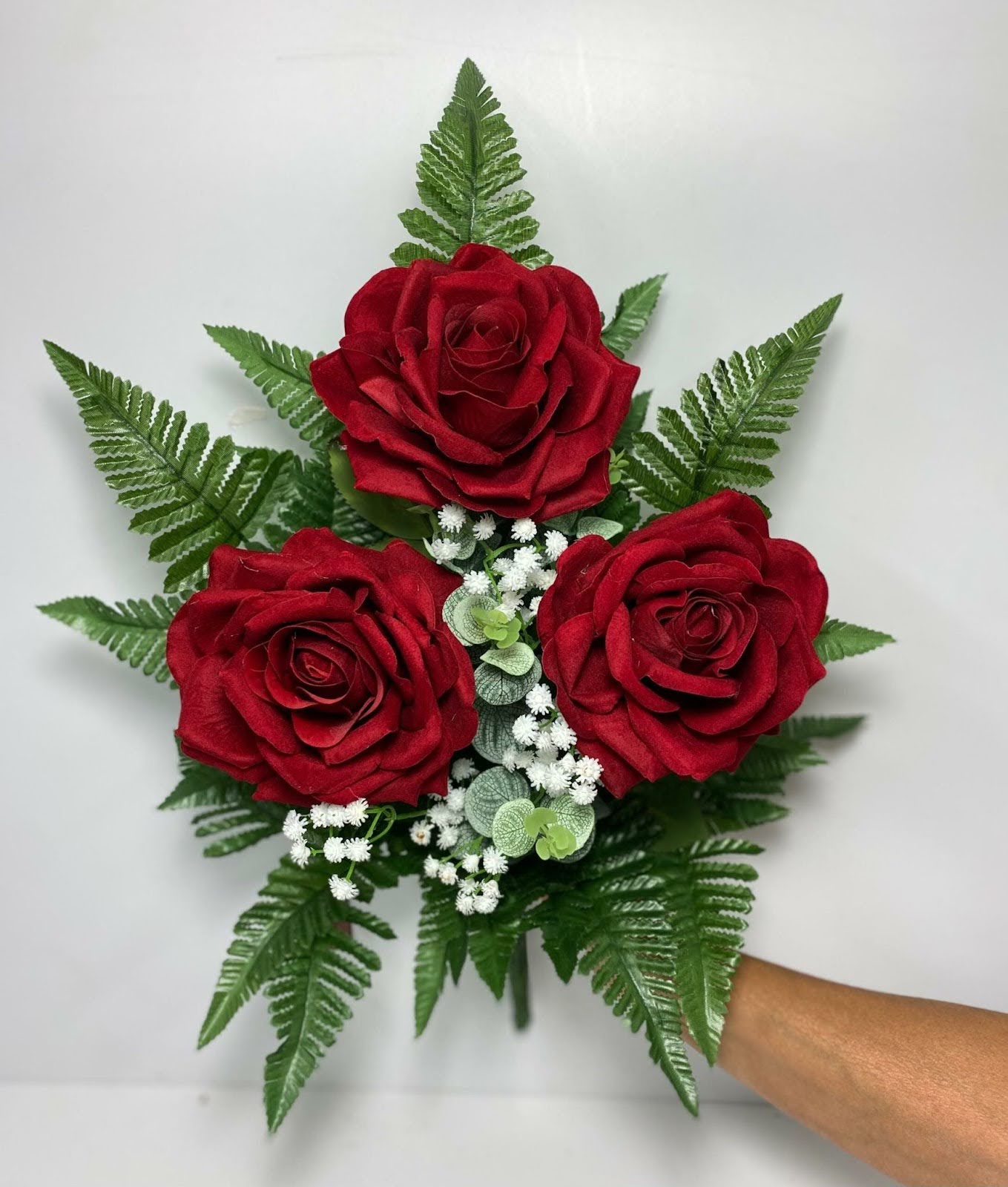 Mazzo di rose rosse artificiali con fogliame verde